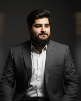Rizwan Ahmed, Co-founder and CMO of JSK LOGICS, with a beard, in a grey suit